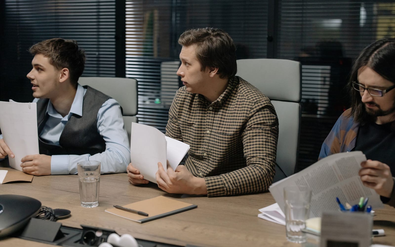 An enterprise meeting in a glass-walled conference room.