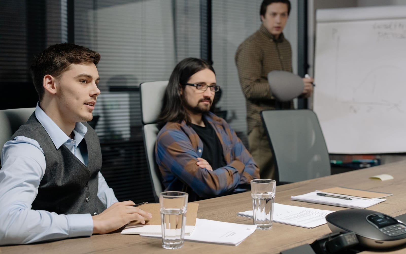 An enterprise meeting in a glass-walled conference room.