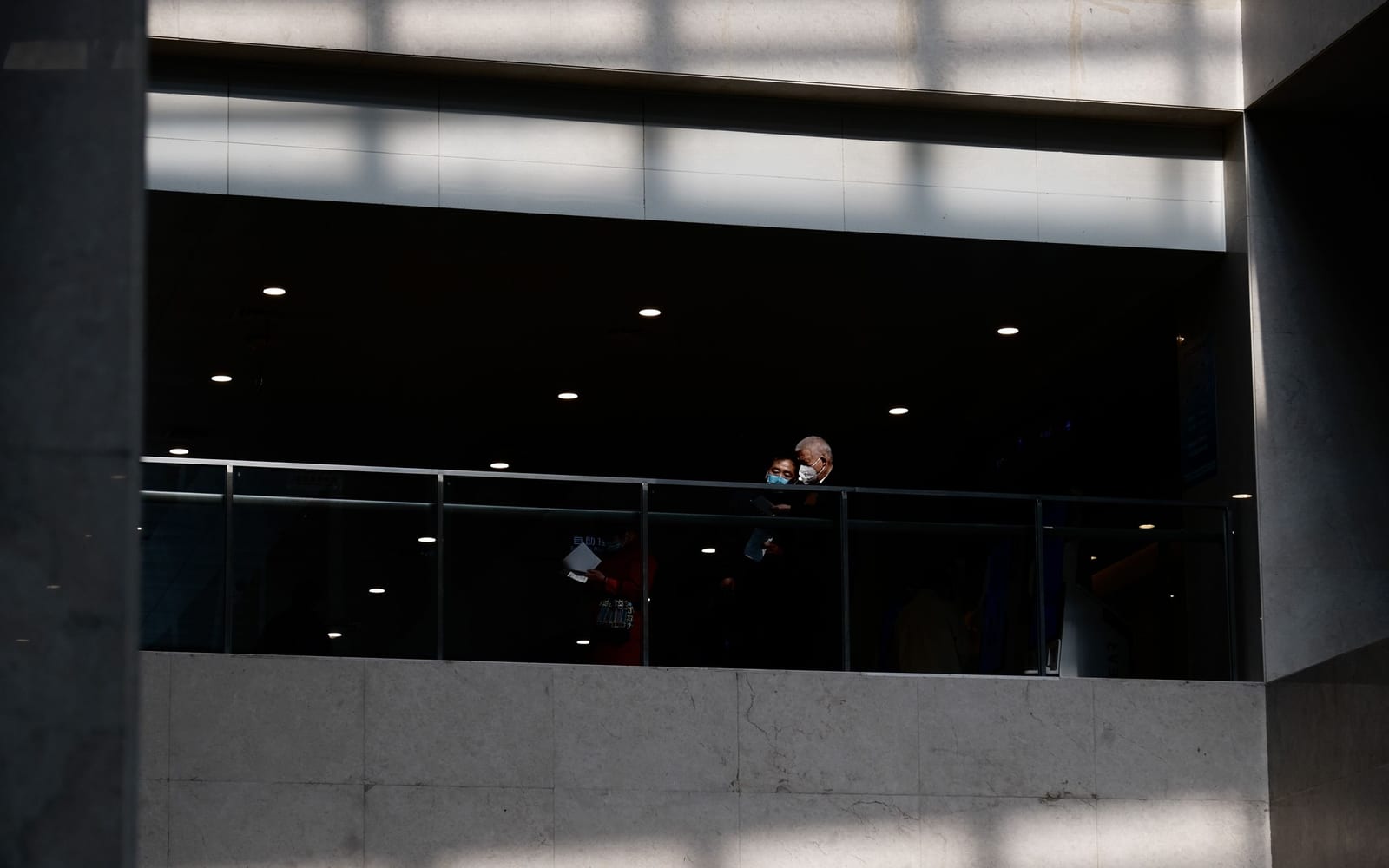 An enterprise meeting in a glass-walled conference room.