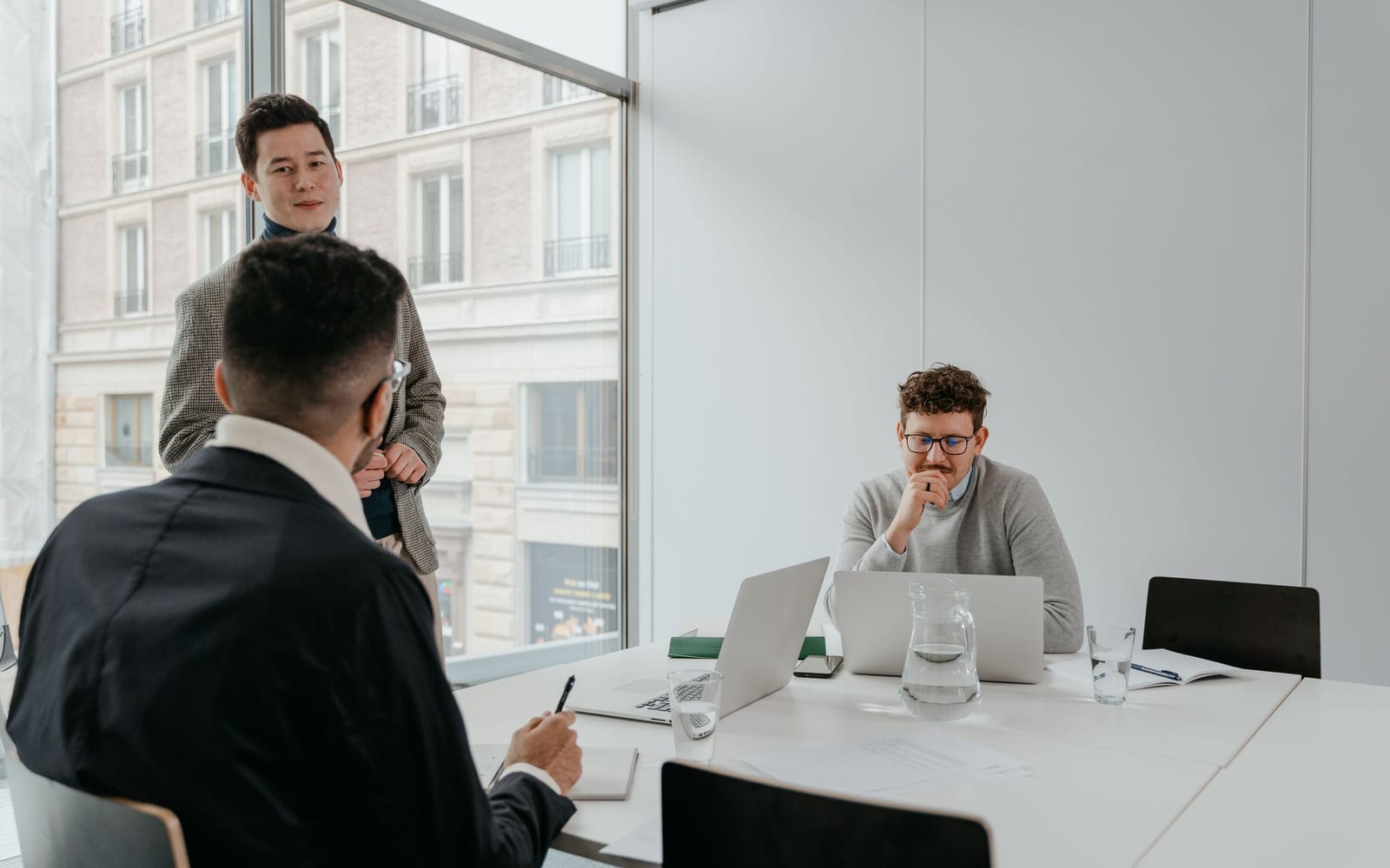 An enterprise meeting in a glass-walled conference room.