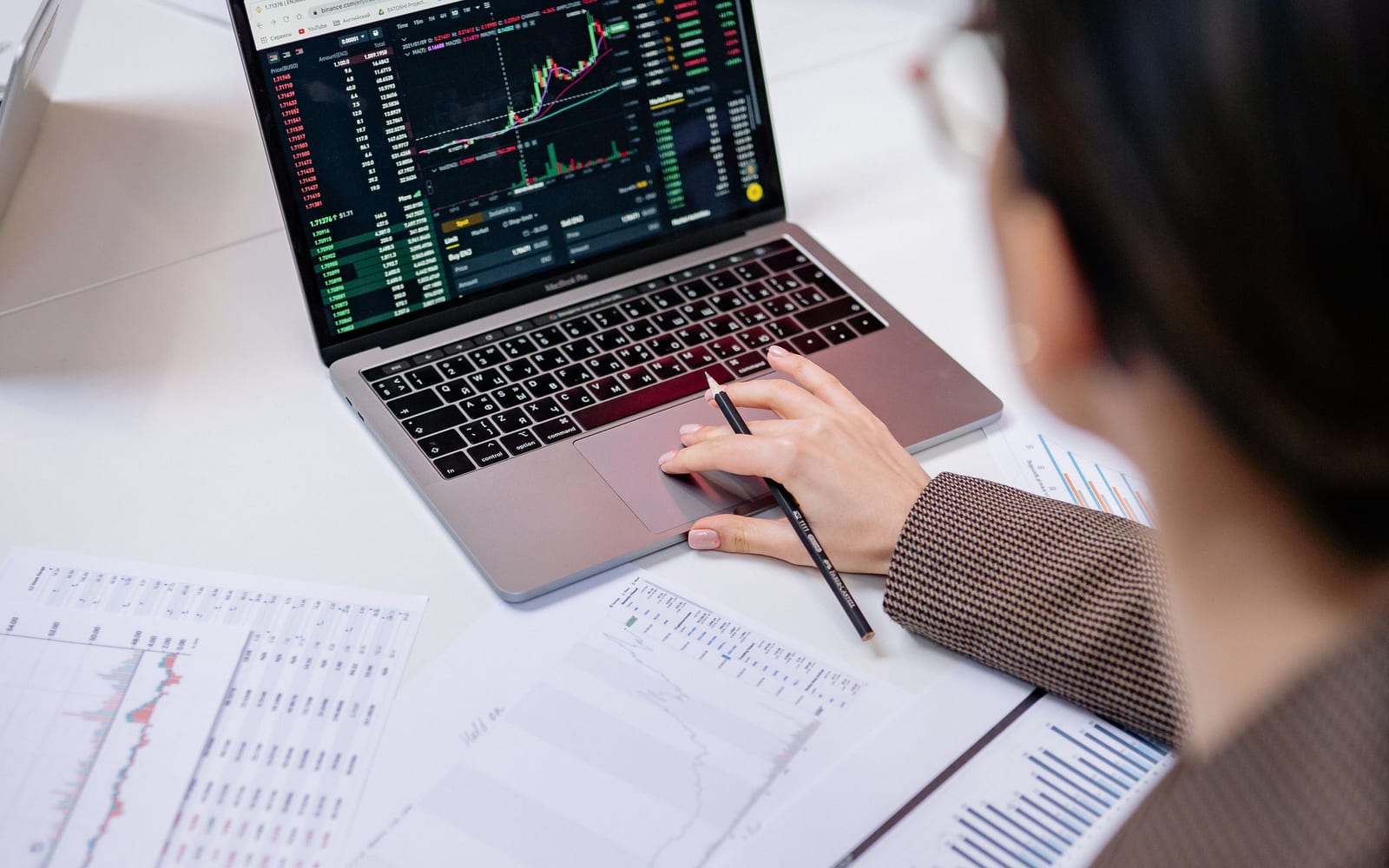 An analyst reviewing figures on a laptop in an office.