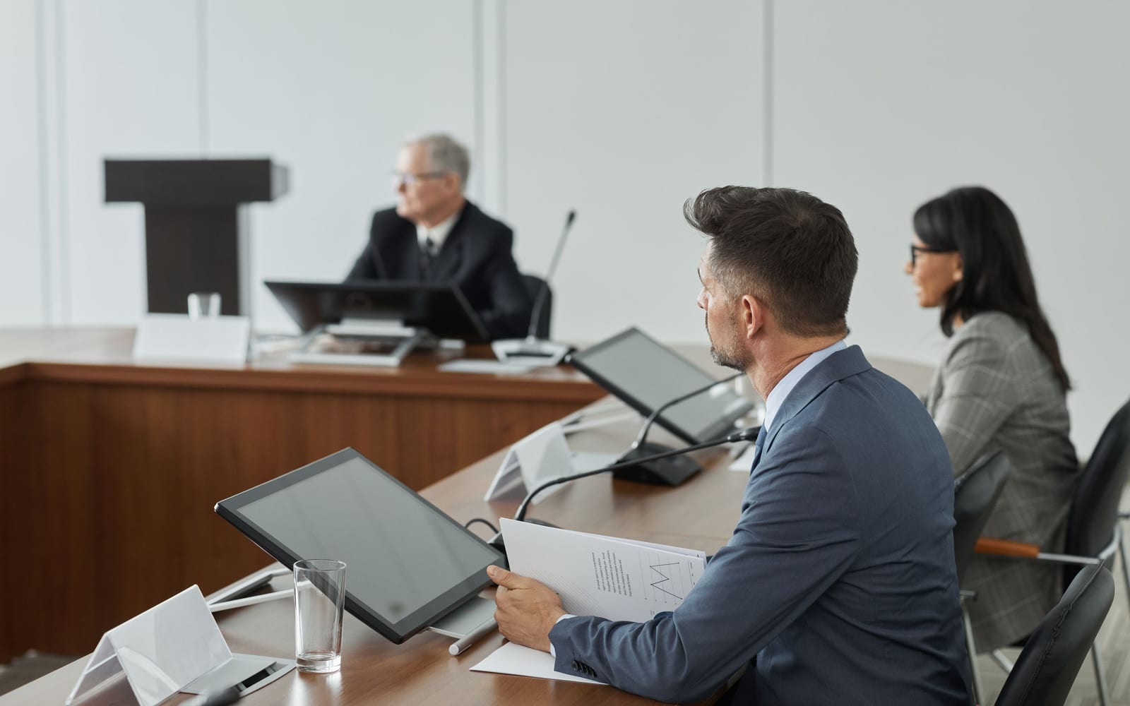 An enterprise meeting in a glass-walled conference room.