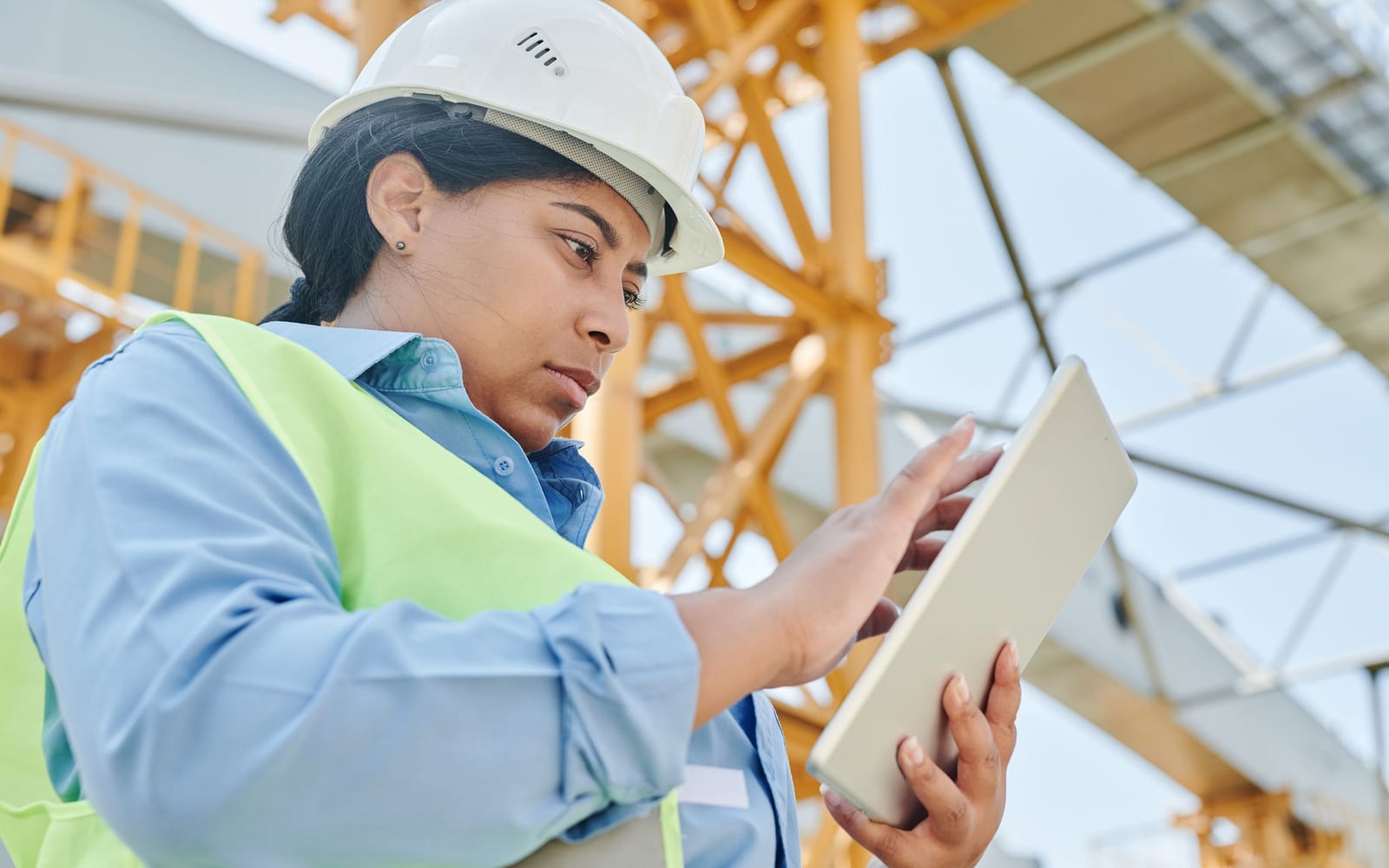 A technician using a tablet on a work site.