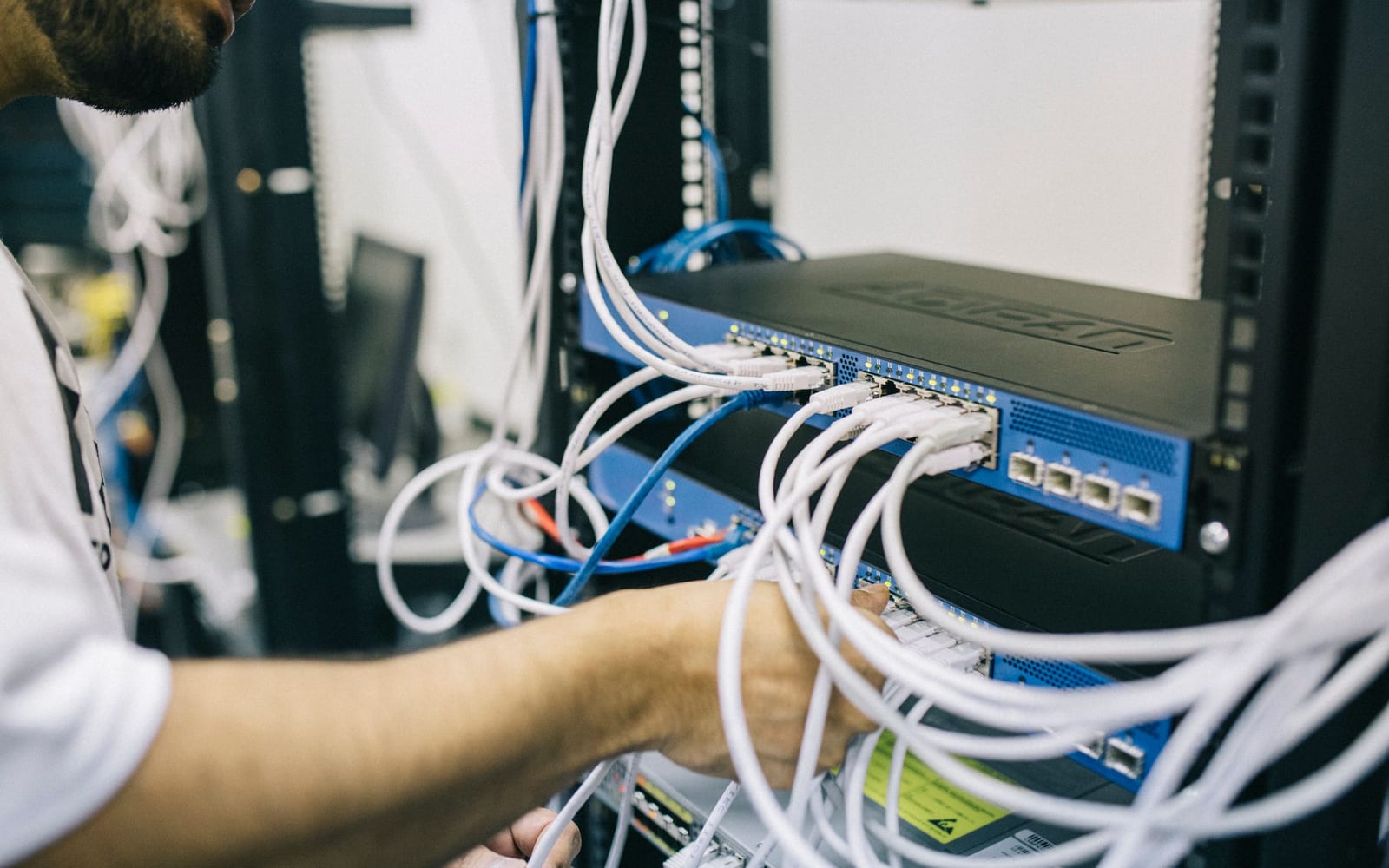 An engineer working beside servers in a data centre.