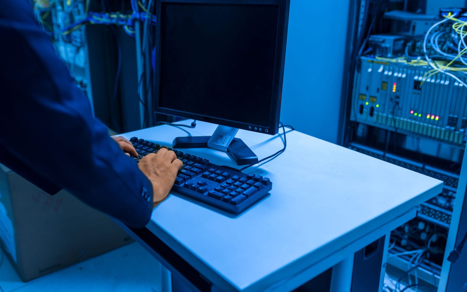 An engineer working beside servers in a data centre.