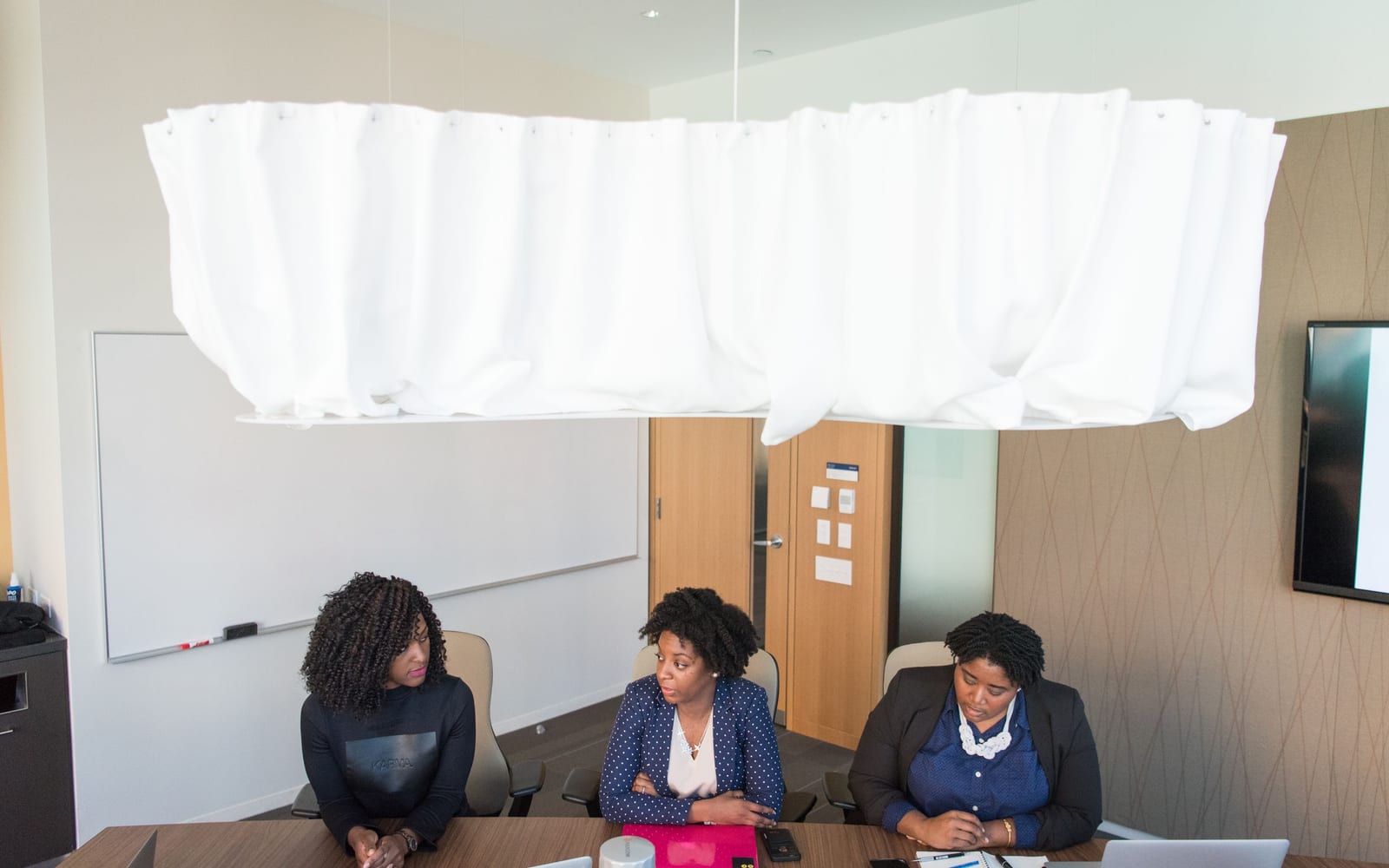 An enterprise meeting in a glass-walled conference room.