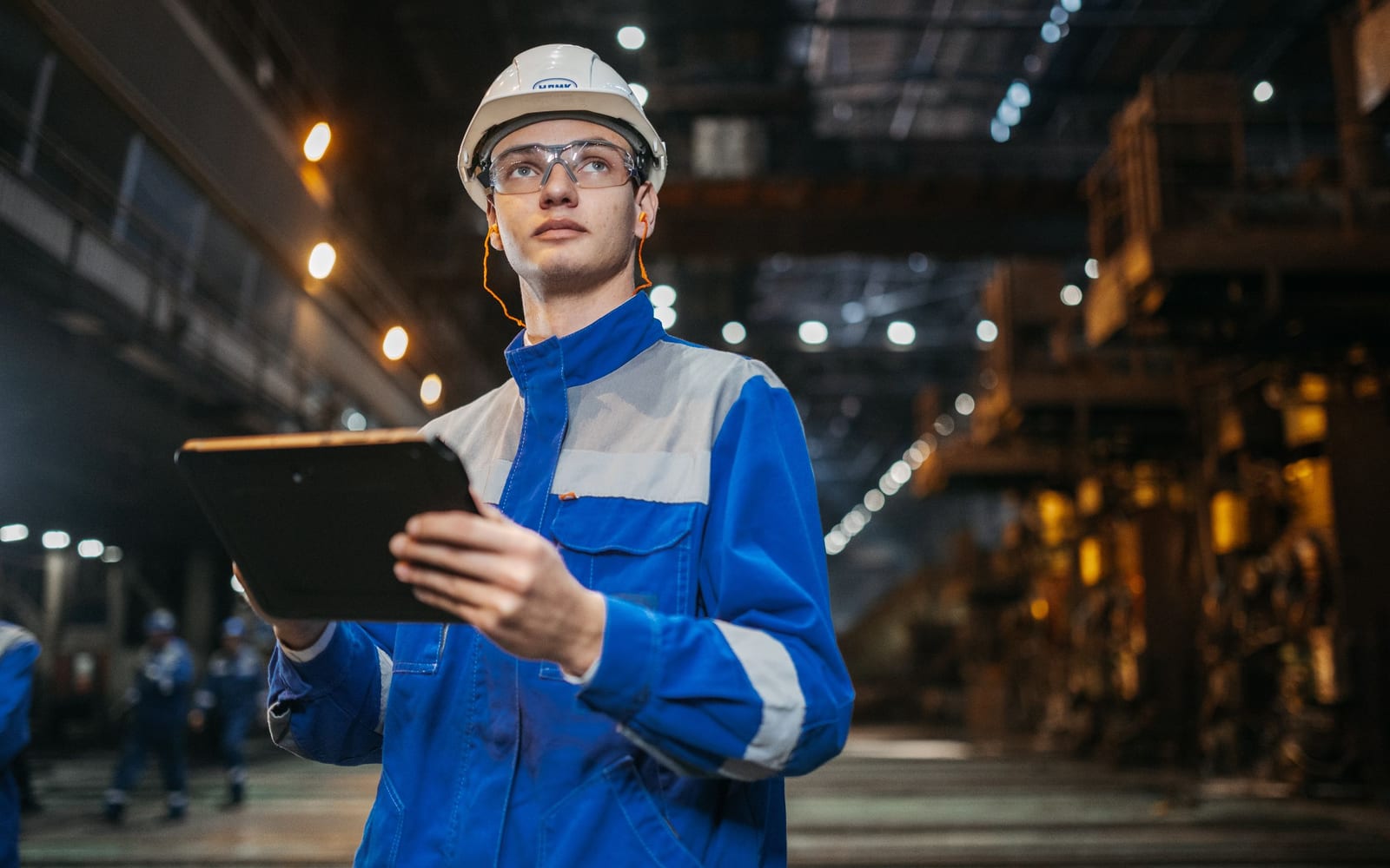 A technician using a tablet on a work site.