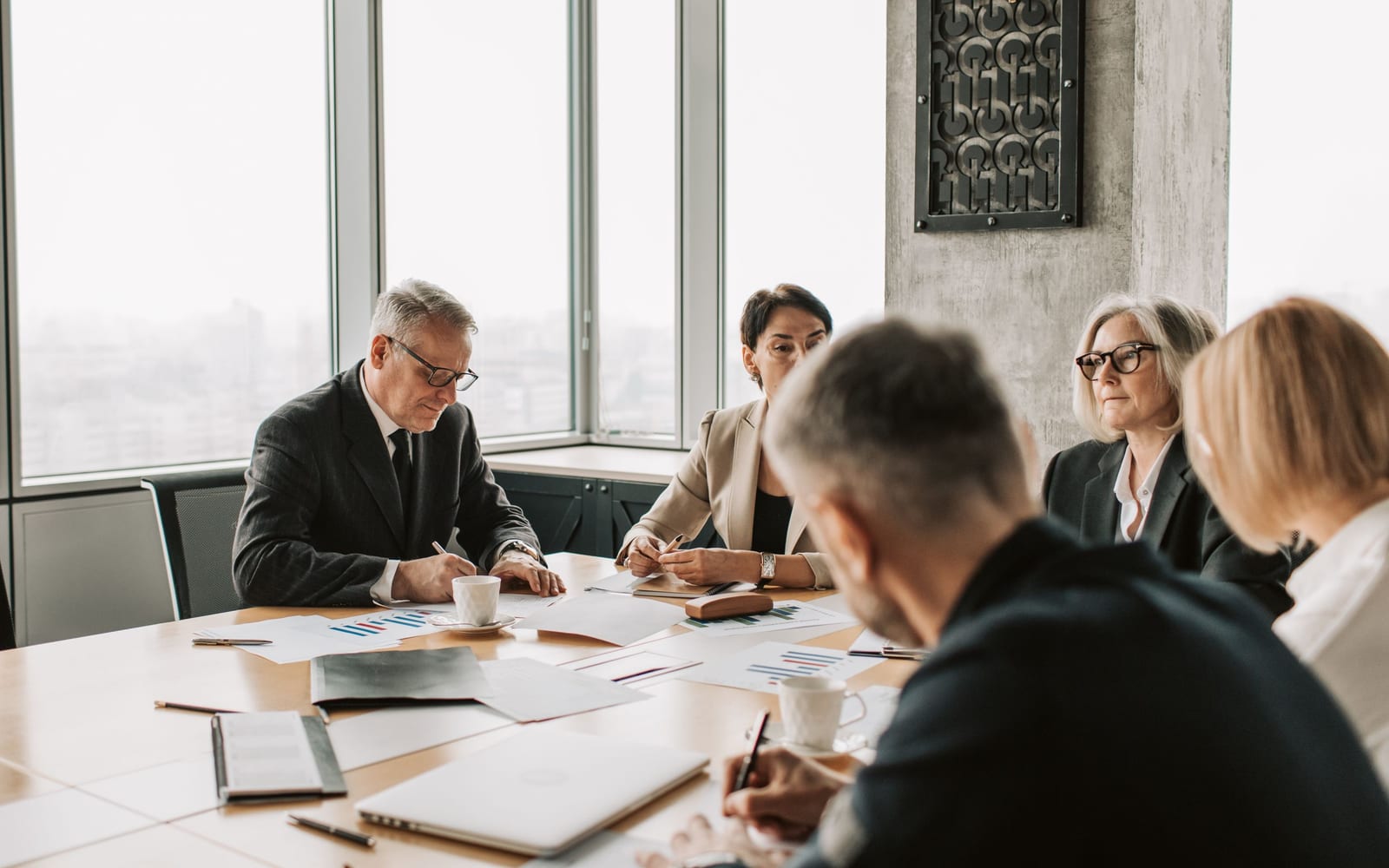 An enterprise meeting in a glass-walled conference room.