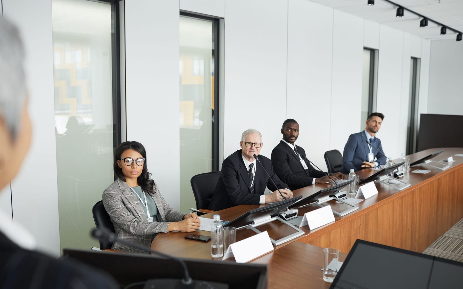 An enterprise meeting in a glass-walled conference room.