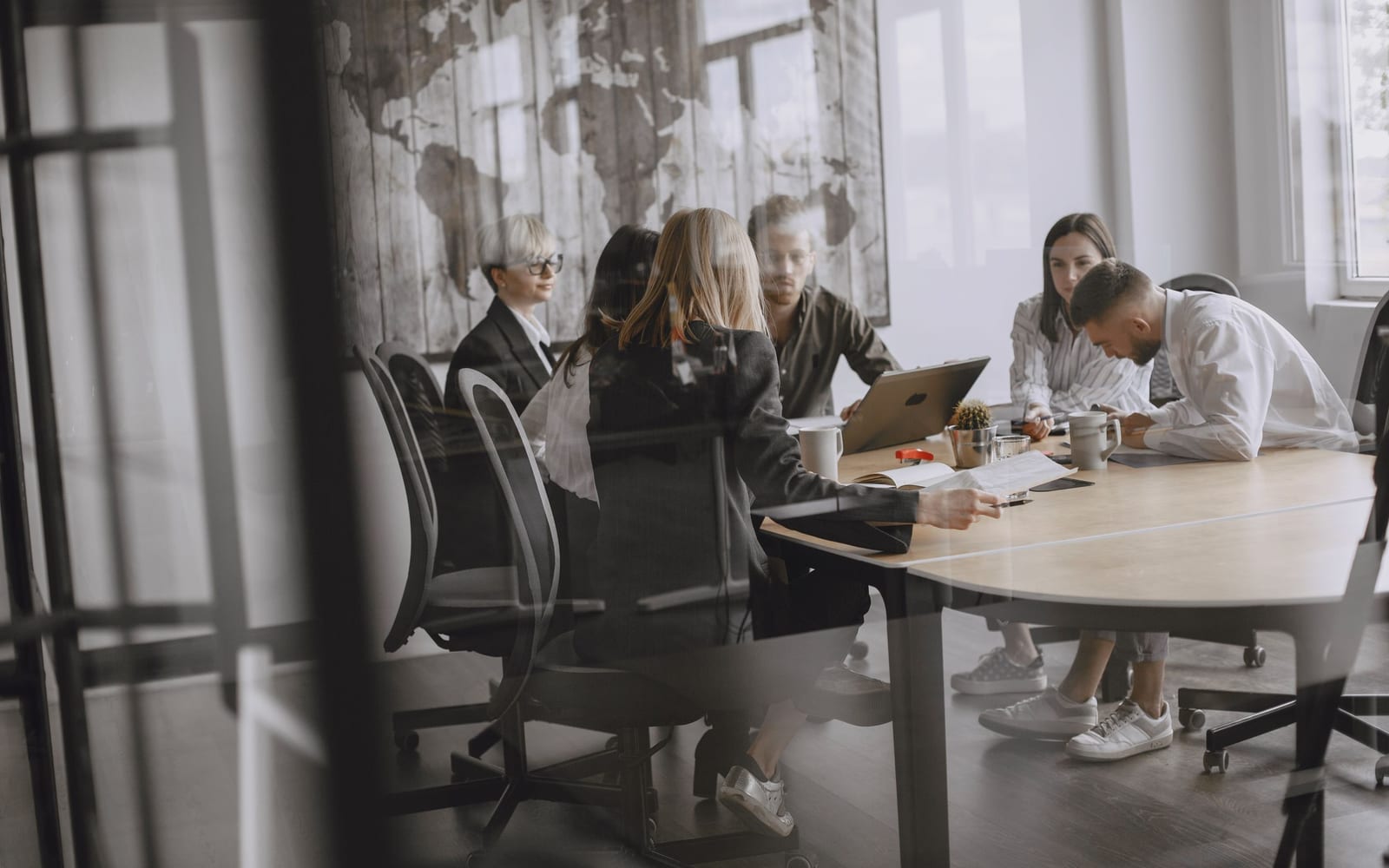 An enterprise meeting in a glass-walled conference room.