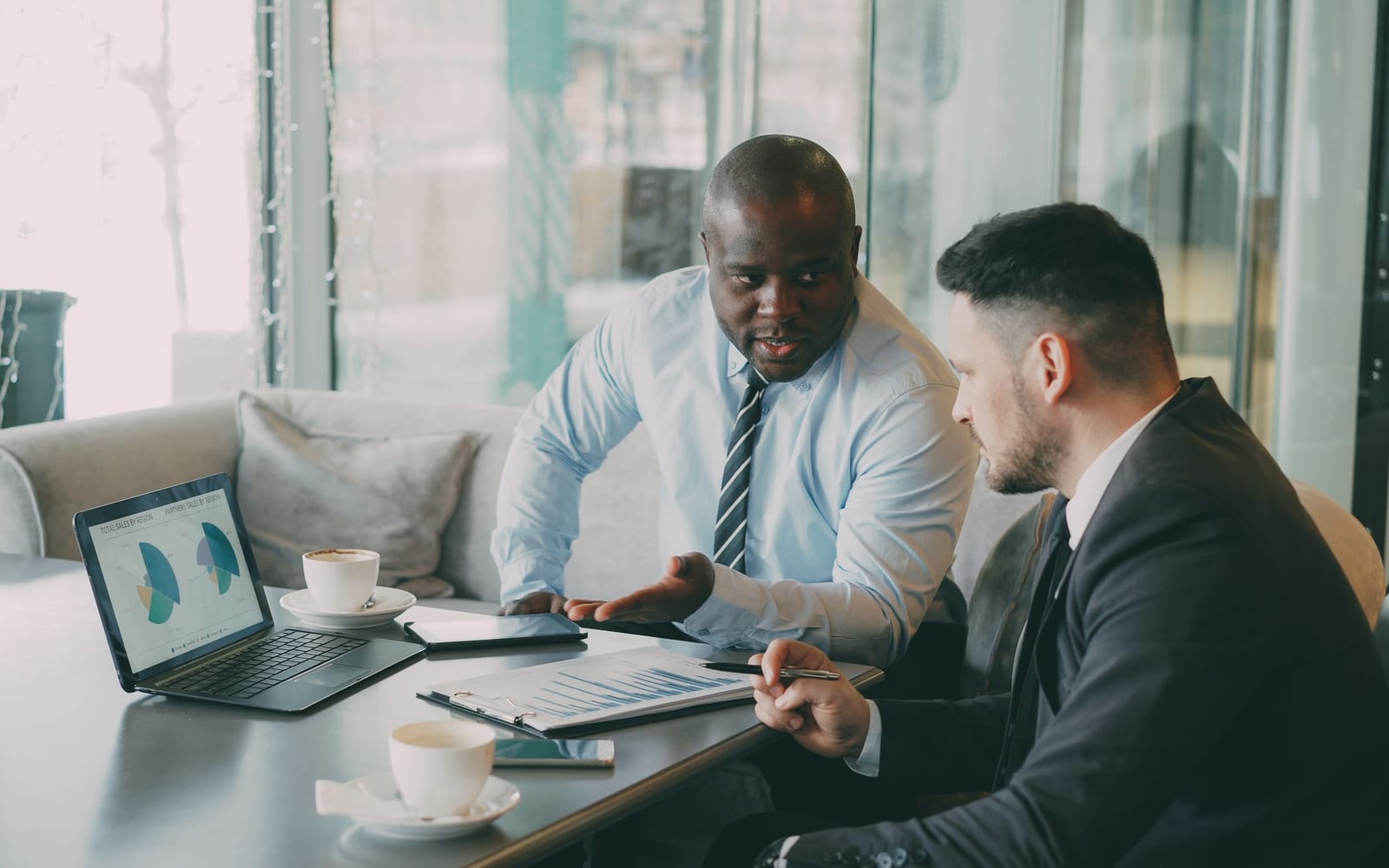An enterprise meeting in a glass-walled conference room.