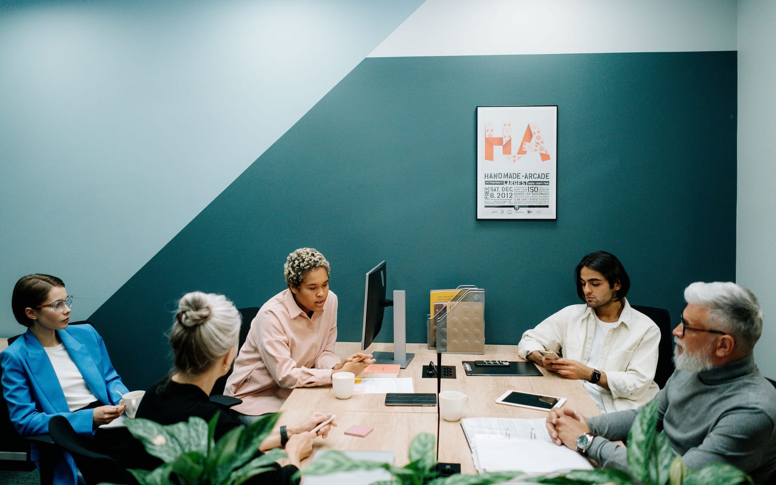 An enterprise meeting in a glass-walled conference room.