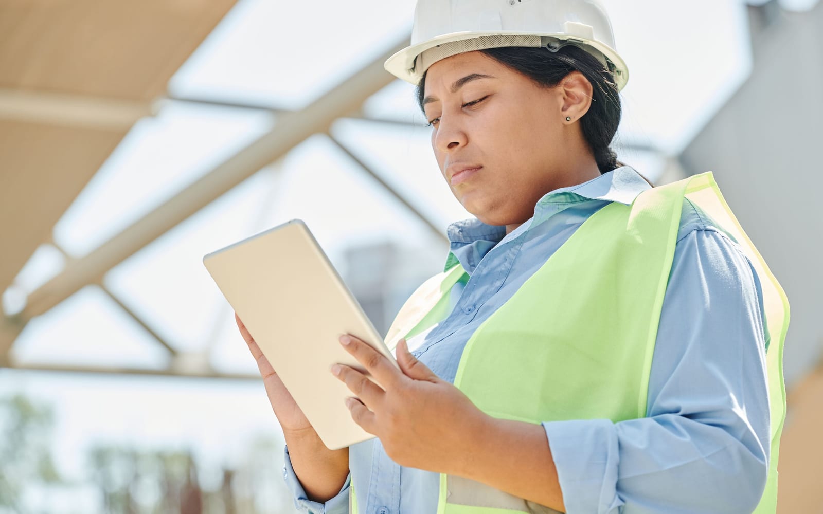 A technician using a tablet on a work site.