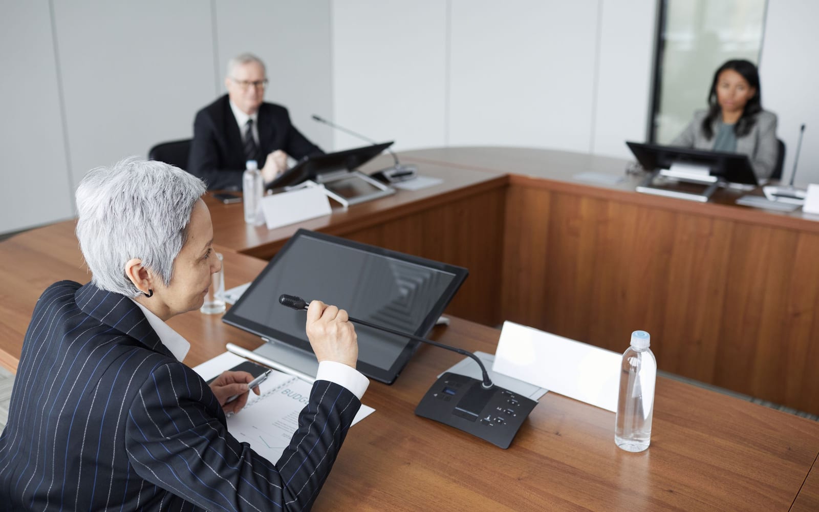 An enterprise meeting in a glass-walled conference room.