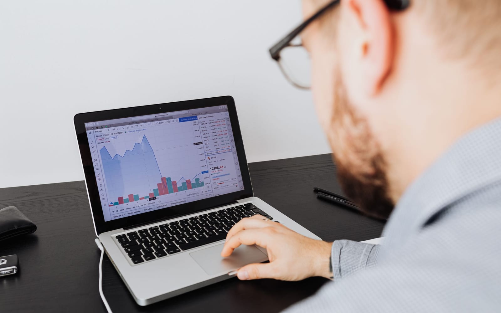 An analyst reviewing figures on a laptop in an office.