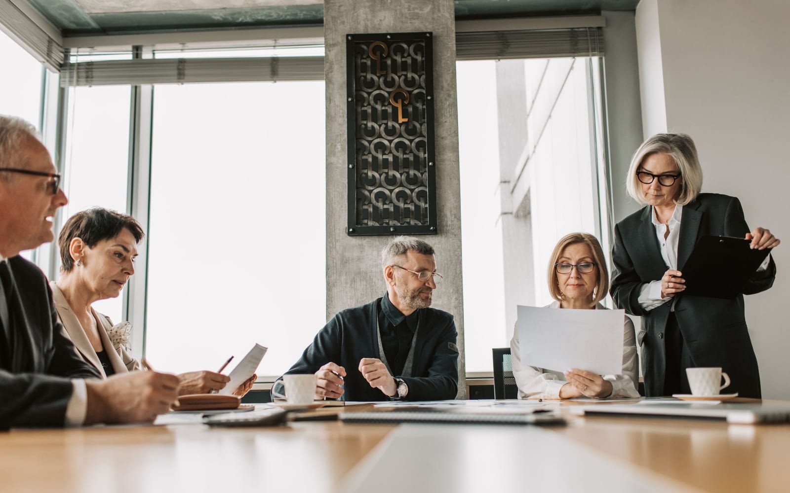 An enterprise meeting in a glass-walled conference room.