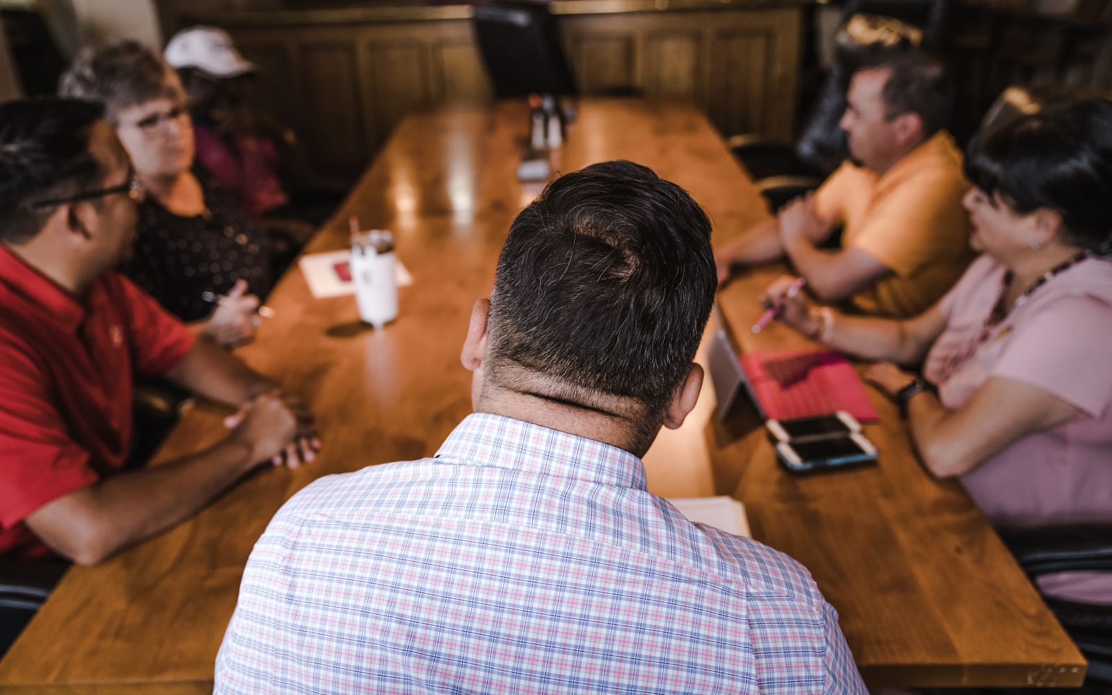 An enterprise meeting in a glass-walled conference room.
