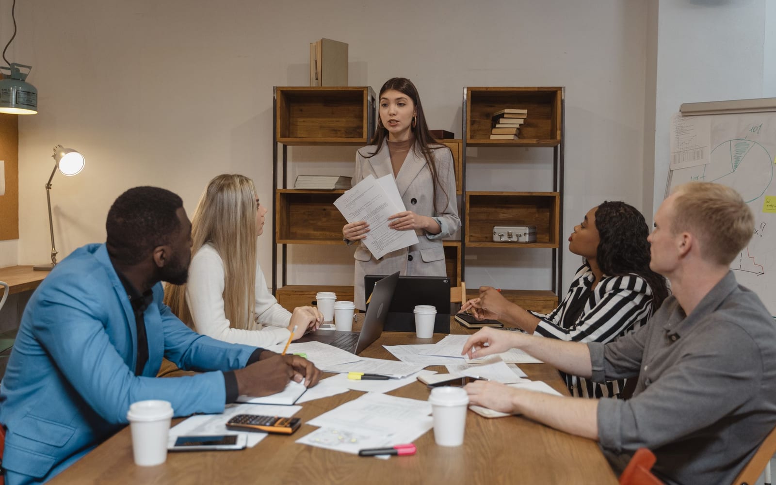 An enterprise meeting in a glass-walled conference room.