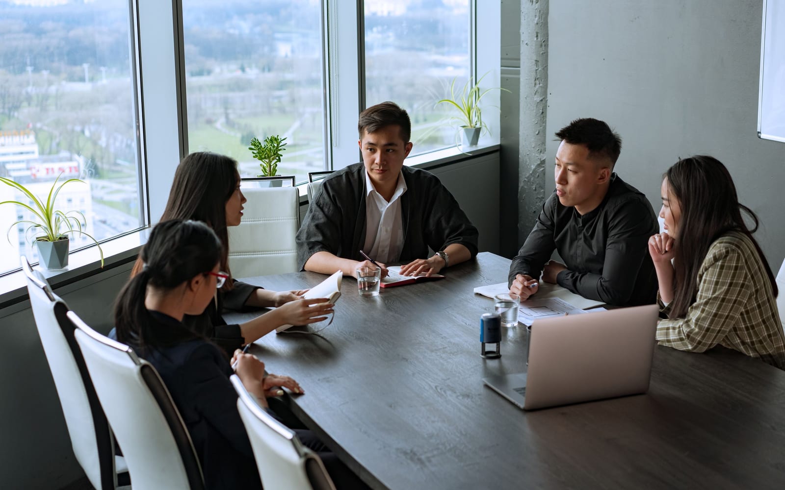 An enterprise meeting in a glass-walled conference room.