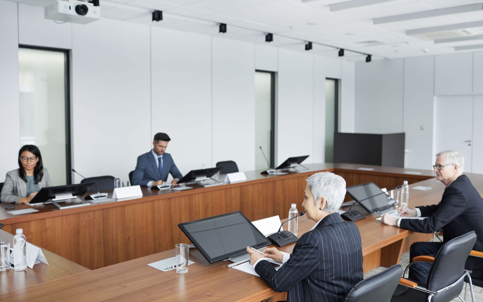 An enterprise meeting in a glass-walled conference room.