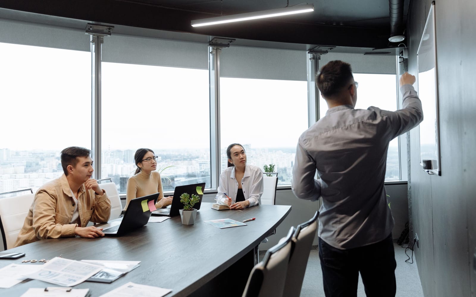 An enterprise meeting in a glass-walled conference room.