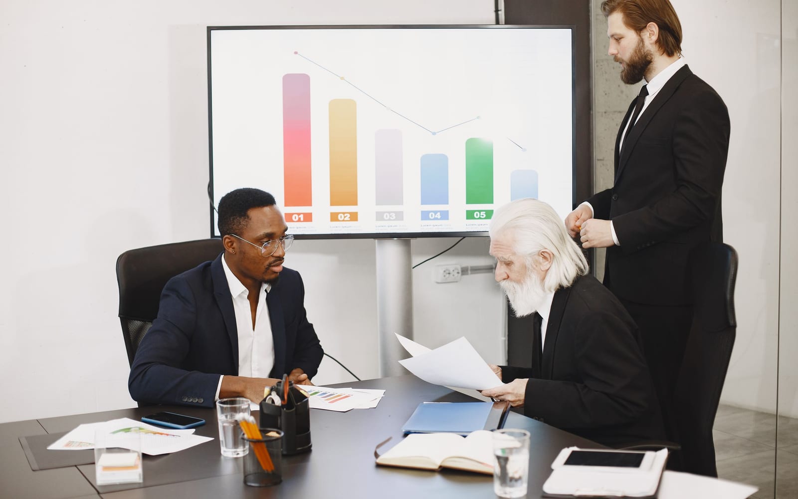 An enterprise meeting in a glass-walled conference room.
