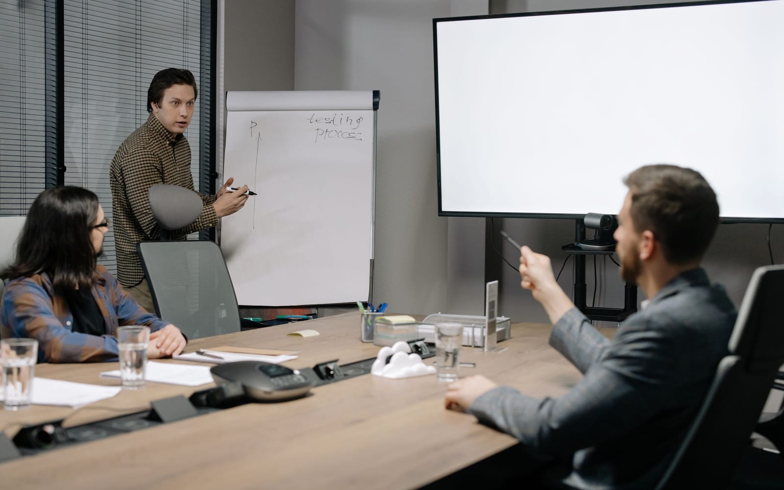 An enterprise meeting in a glass-walled conference room.