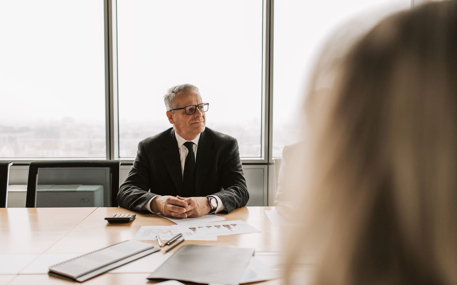 An enterprise meeting in a glass-walled conference room.