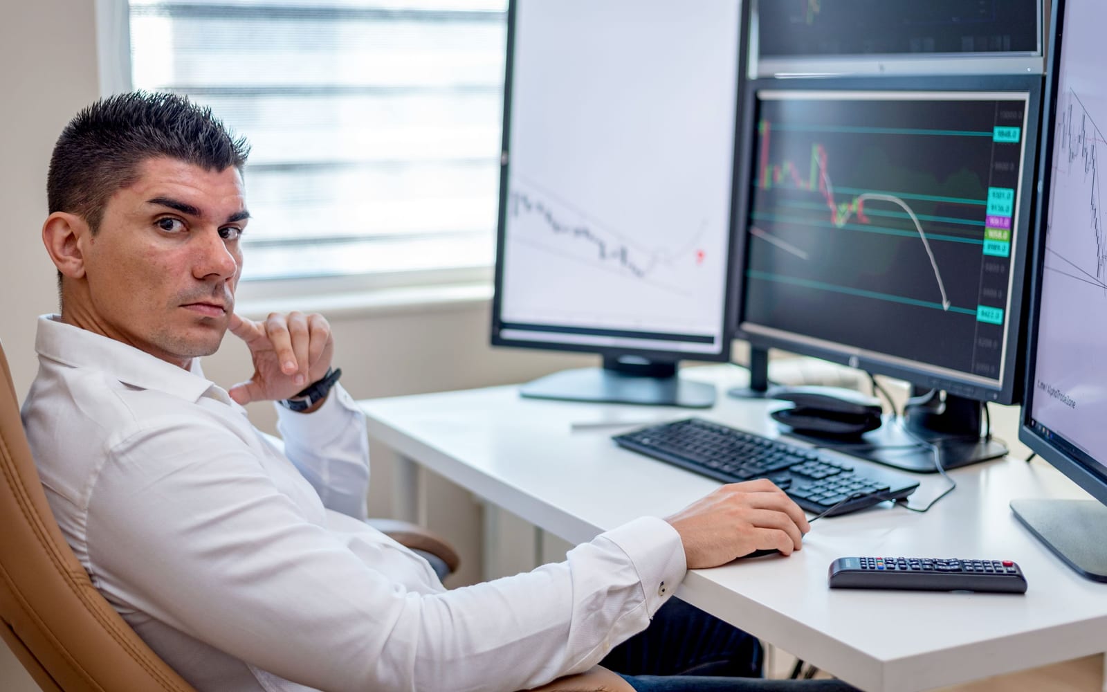 An analyst reviewing figures on a laptop in an office.