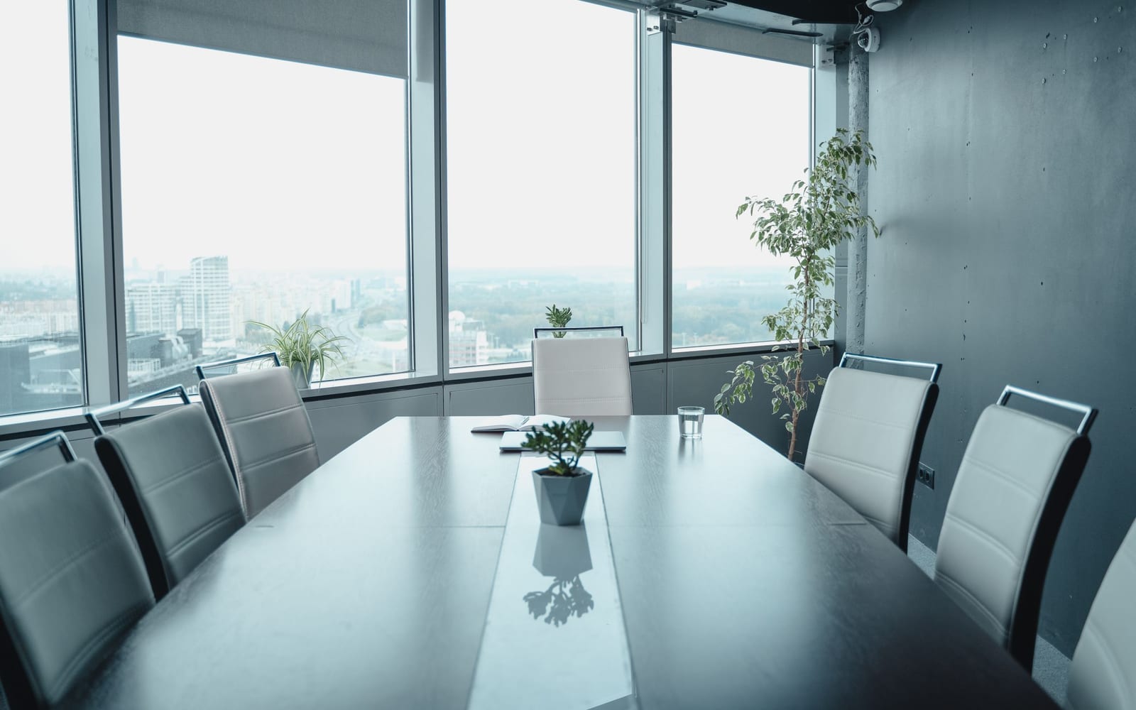 An enterprise meeting in a glass-walled conference room.