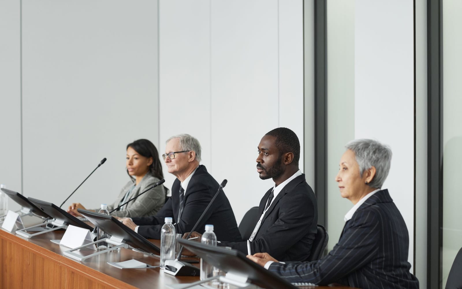 An enterprise meeting in a glass-walled conference room.