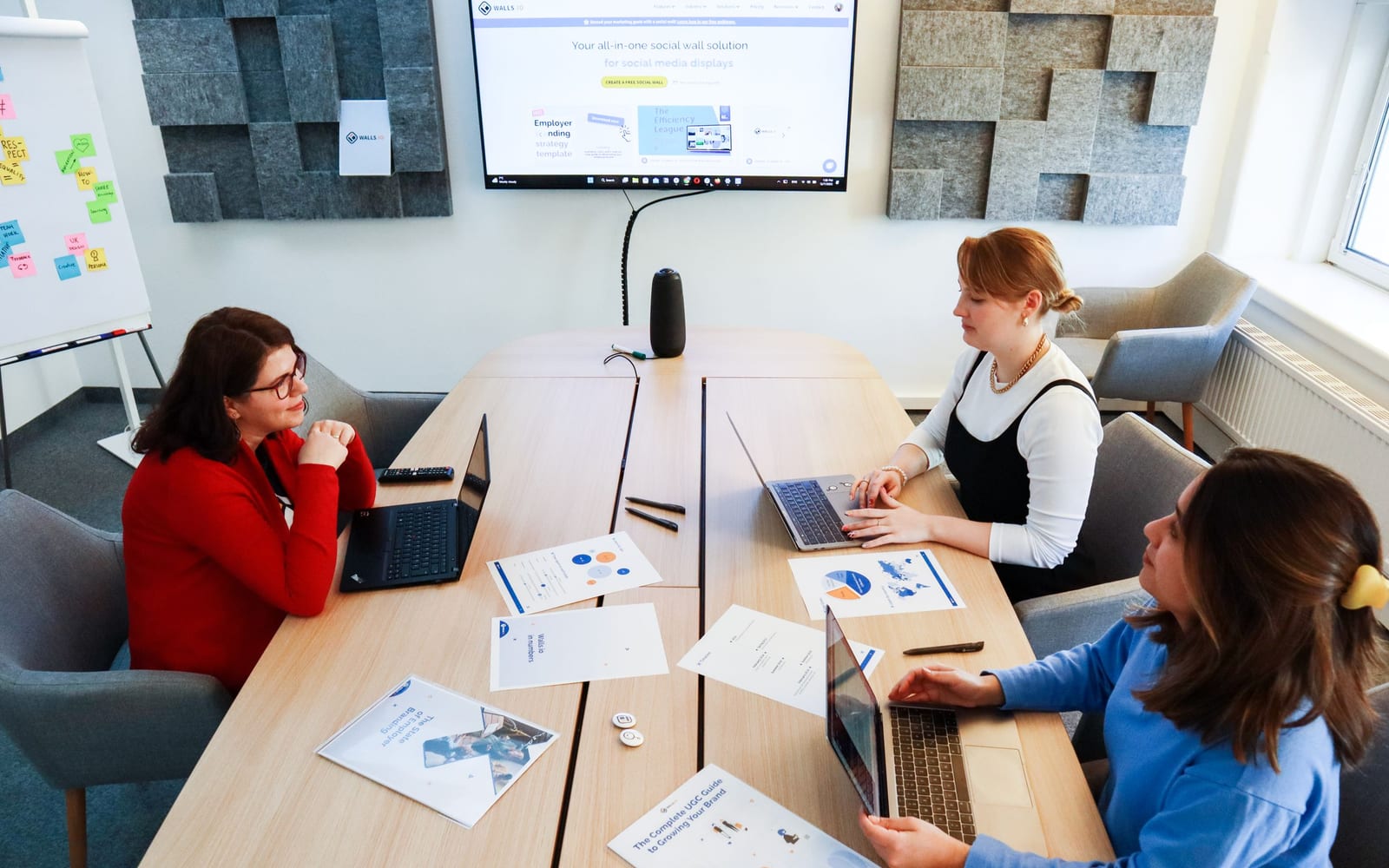 An enterprise meeting in a glass-walled conference room.