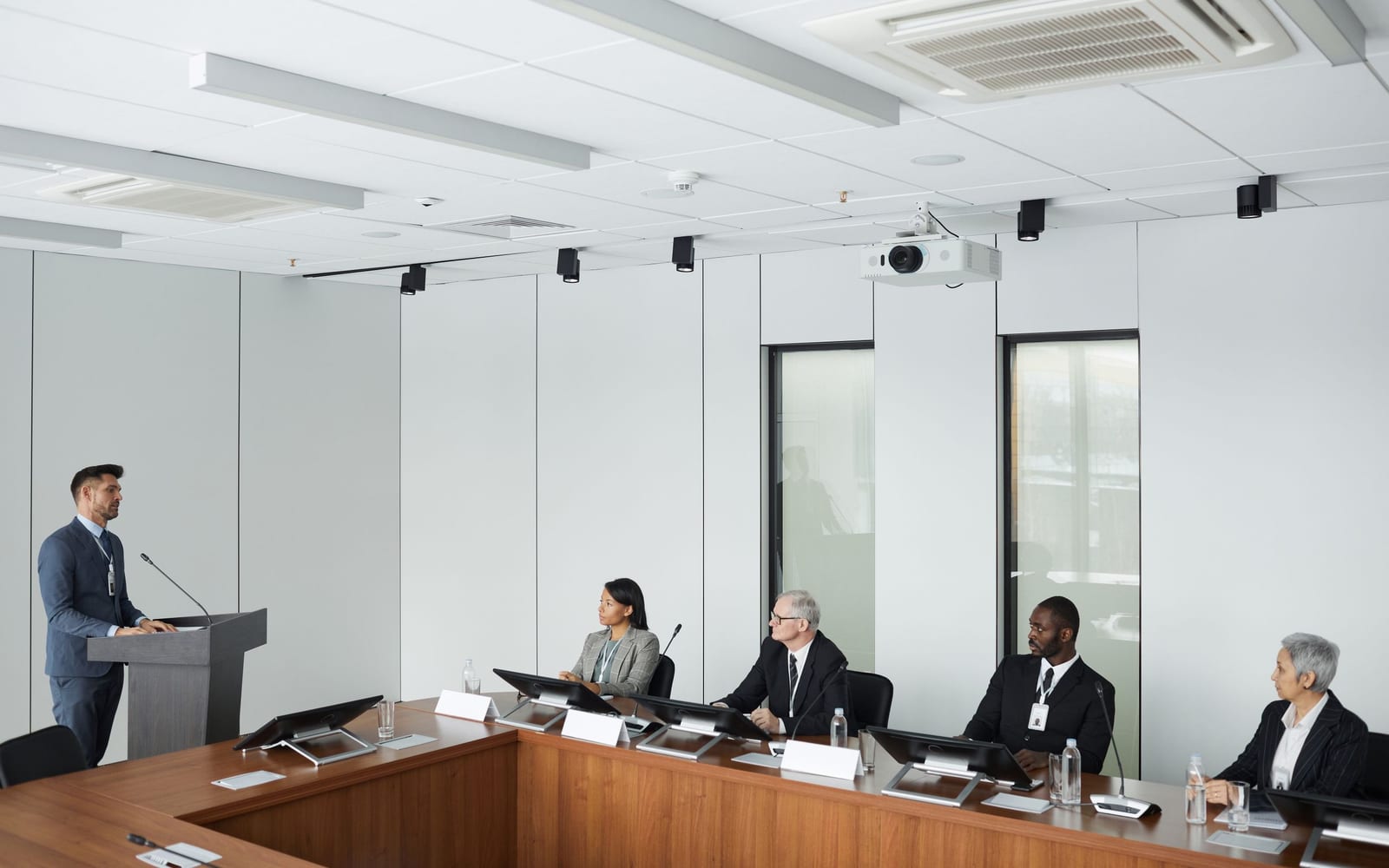 An enterprise meeting in a glass-walled conference room.