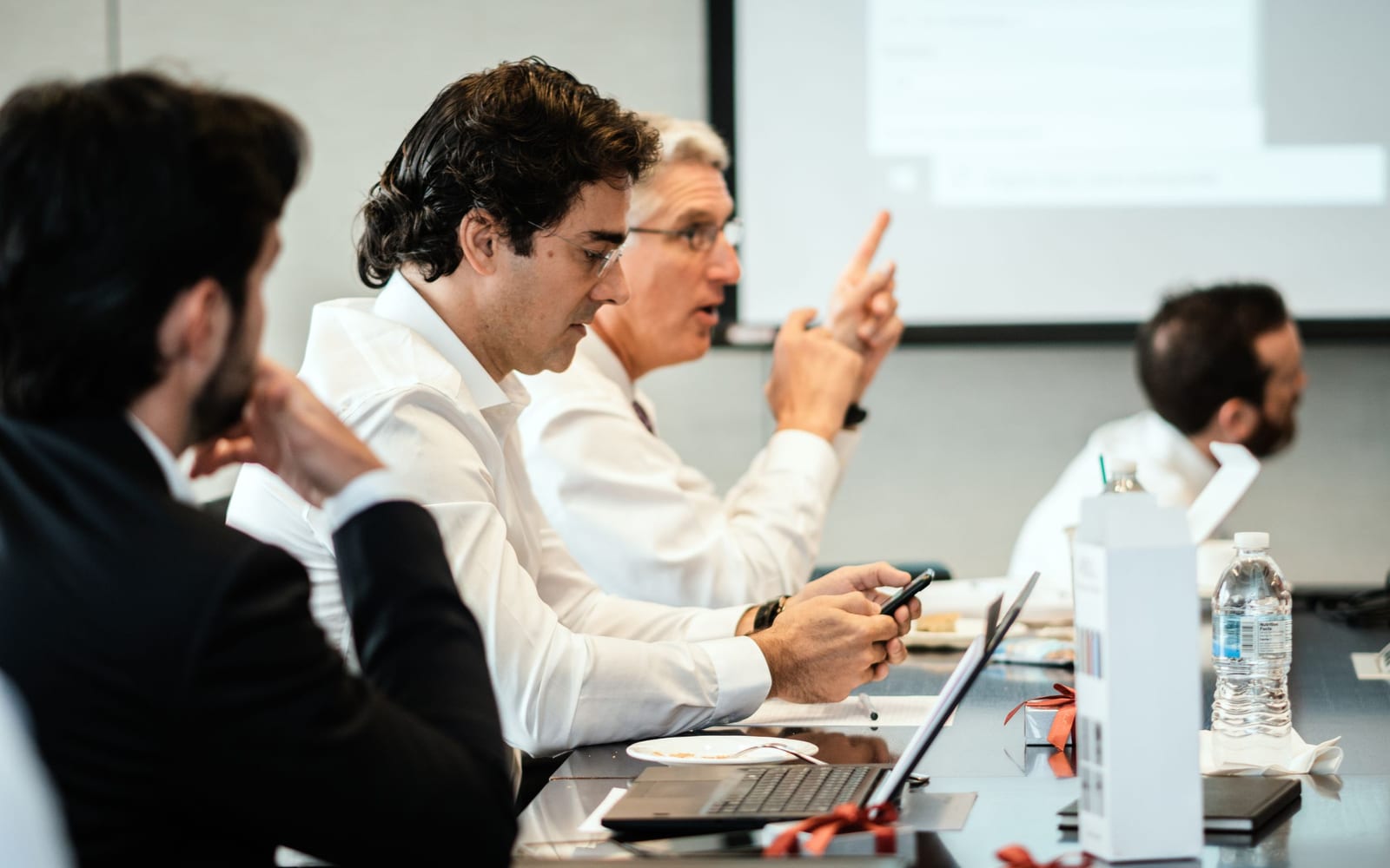 An enterprise meeting in a glass-walled conference room.