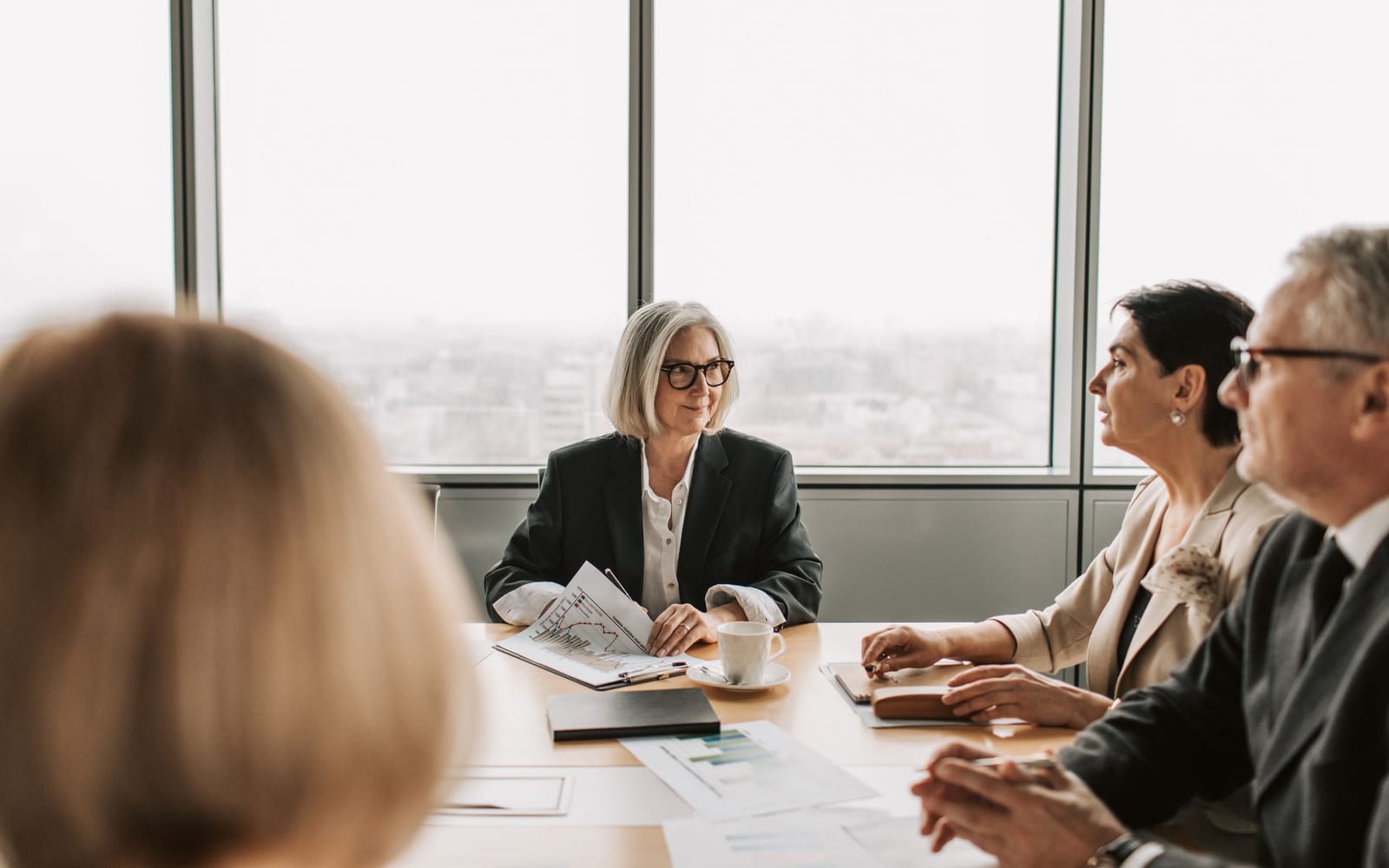 An enterprise meeting in a glass-walled conference room.