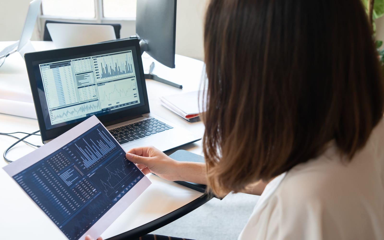 An analyst reviewing figures on a laptop in an office.