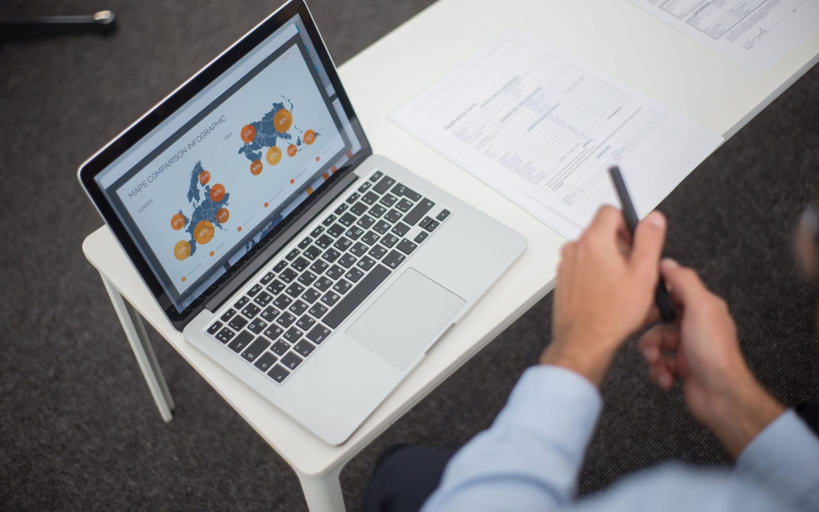 An analyst reviewing figures on a laptop in an office.