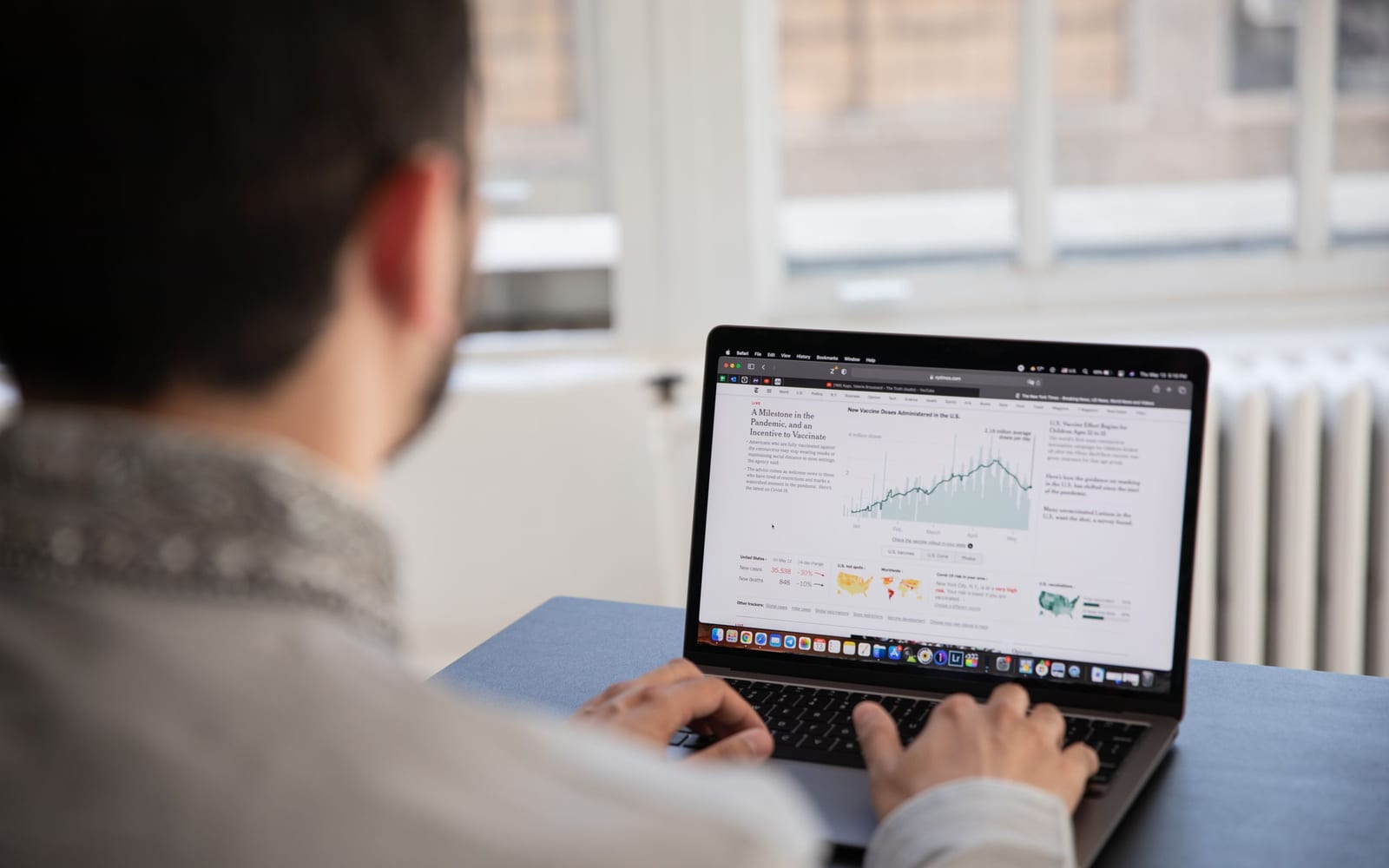 An analyst reviewing figures on a laptop in an office.
