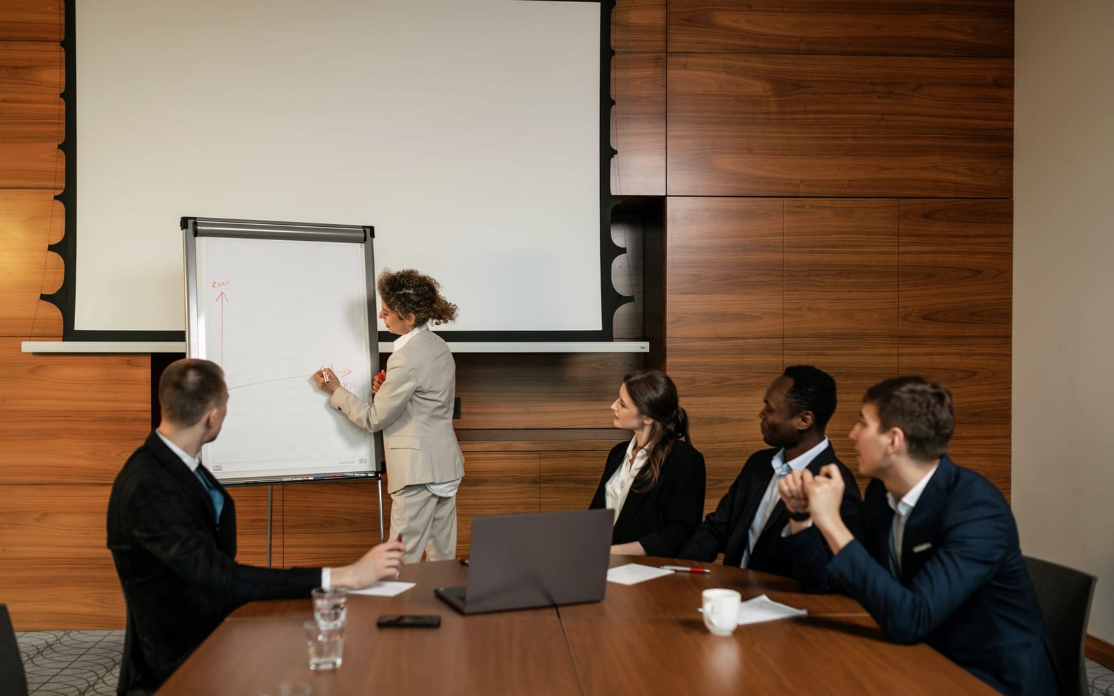An enterprise meeting in a glass-walled conference room.