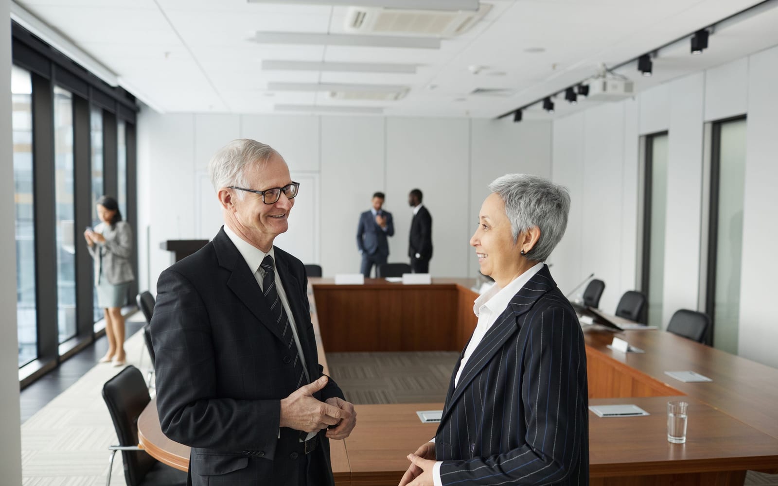 An enterprise meeting in a glass-walled conference room.