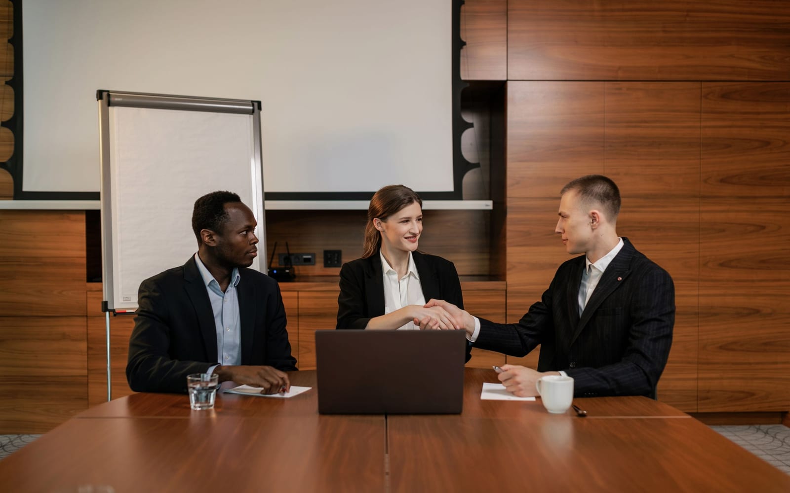 An enterprise meeting in a glass-walled conference room.