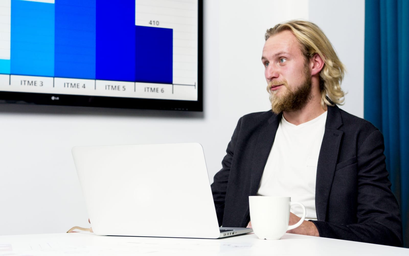 An analyst reviewing figures on a laptop in an office.