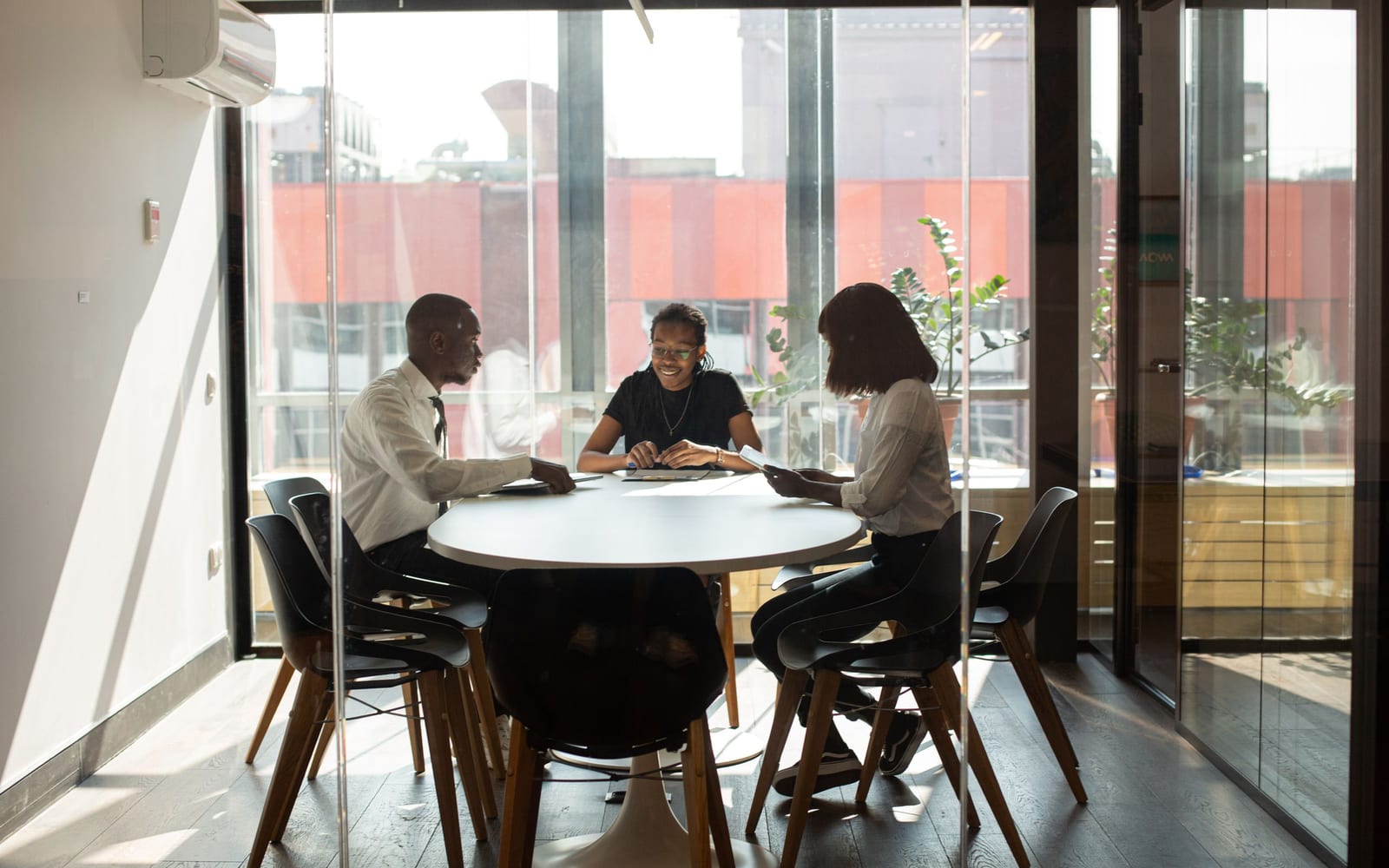An enterprise meeting in a glass-walled conference room.