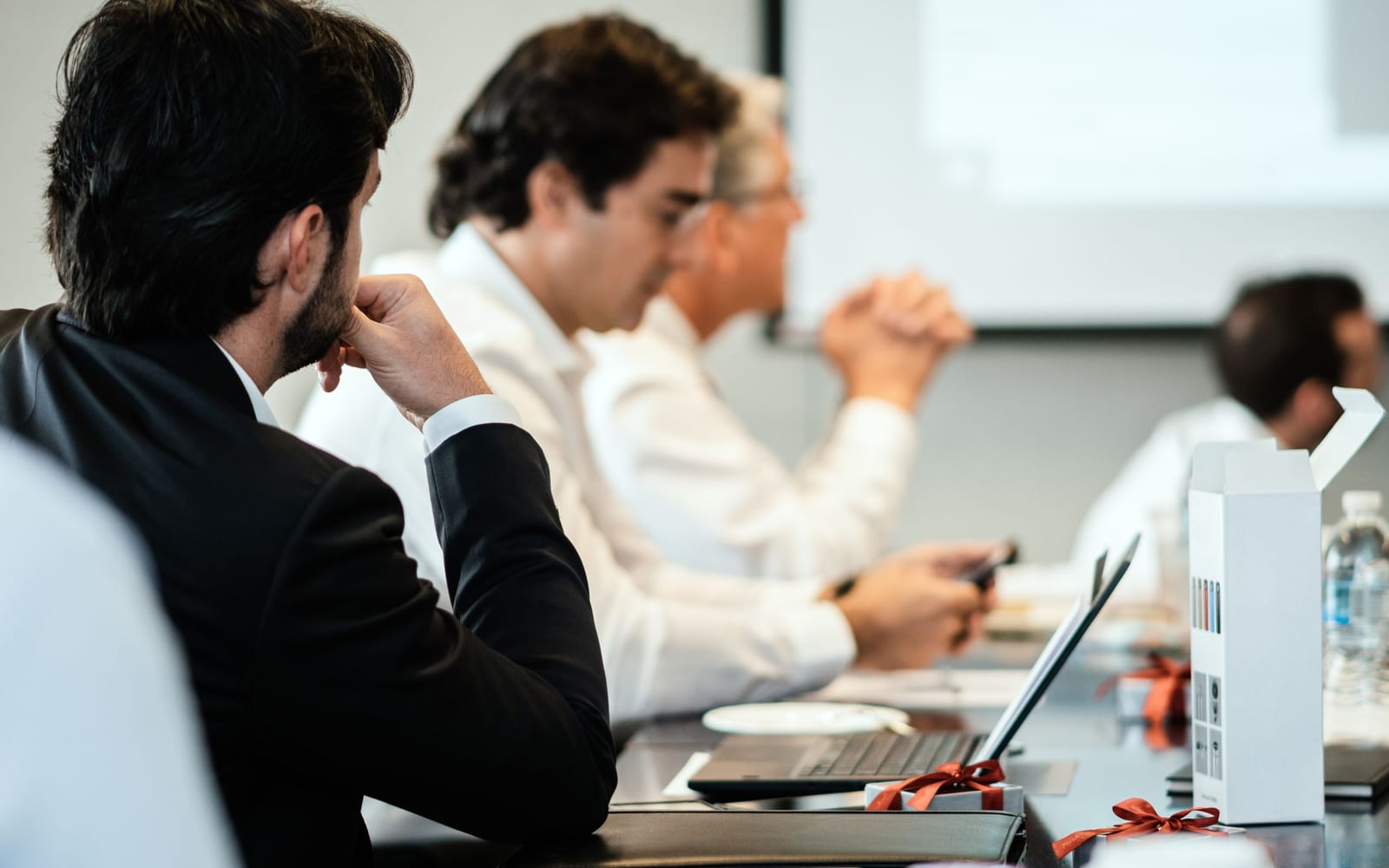 An enterprise meeting in a glass-walled conference room.