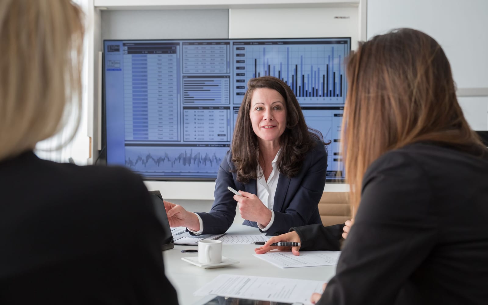 An enterprise meeting in a glass-walled conference room.
