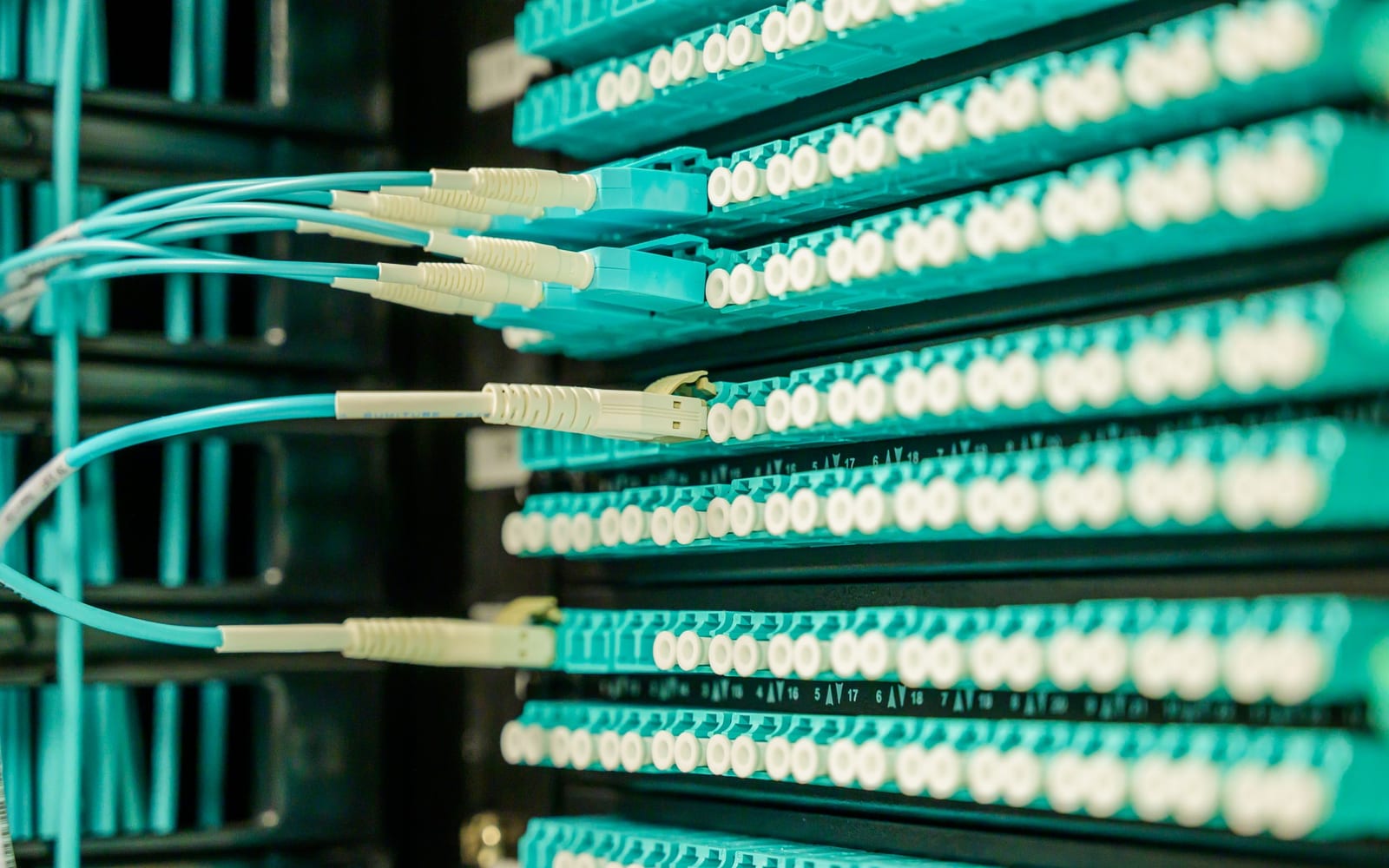An engineer working beside servers in a data centre.