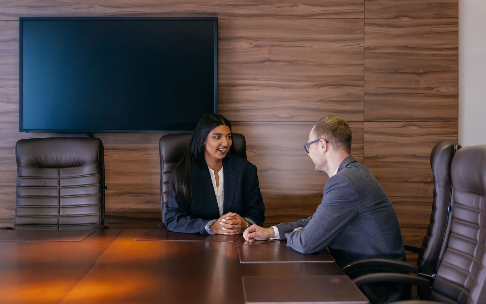 An enterprise meeting in a glass-walled conference room.