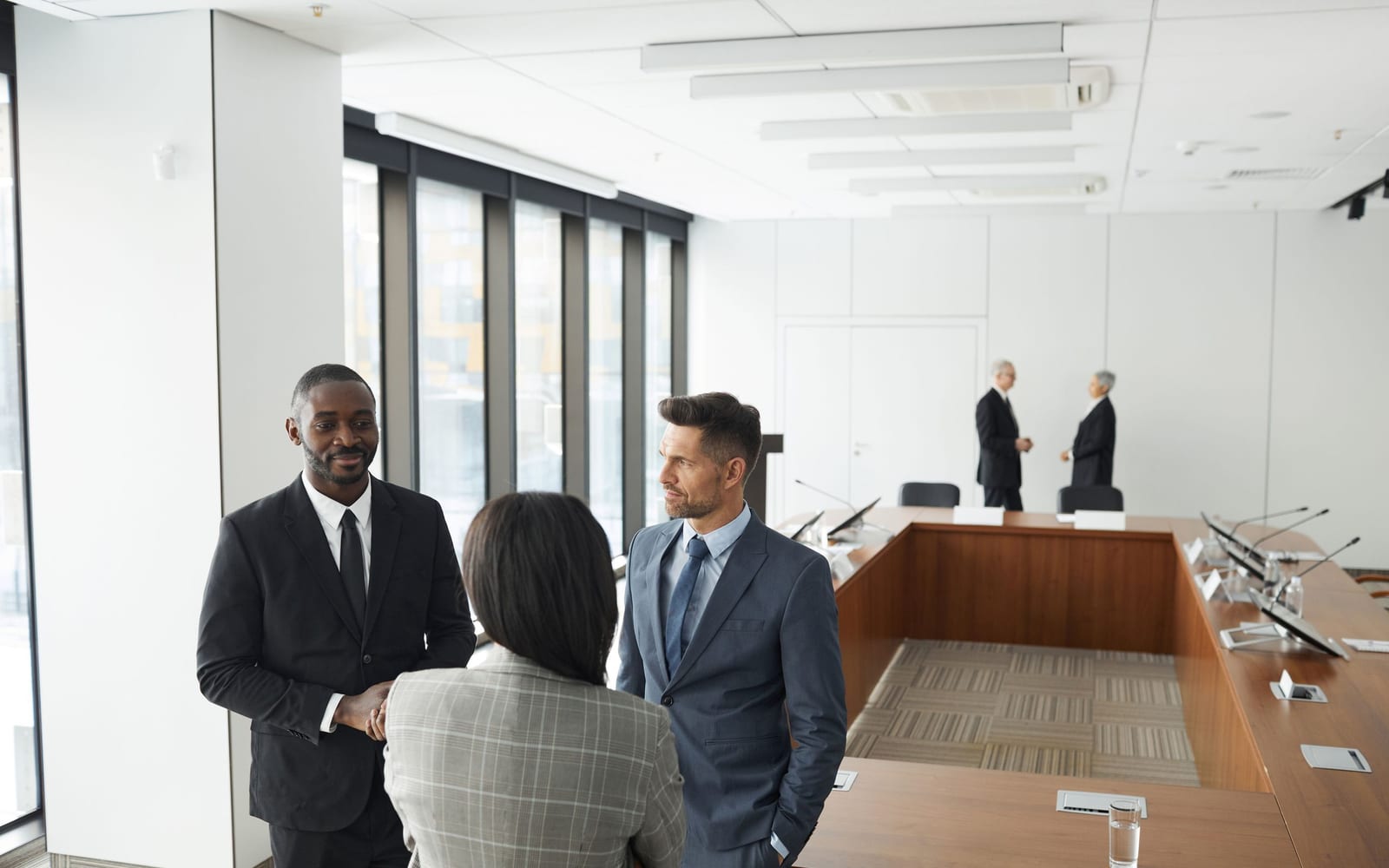 An enterprise meeting in a glass-walled conference room.