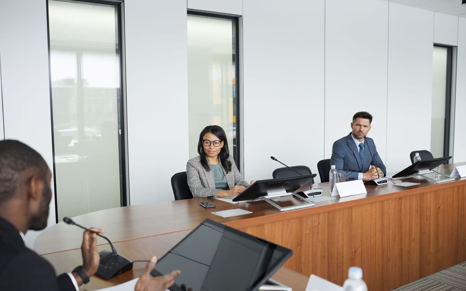 An enterprise meeting in a glass-walled conference room.