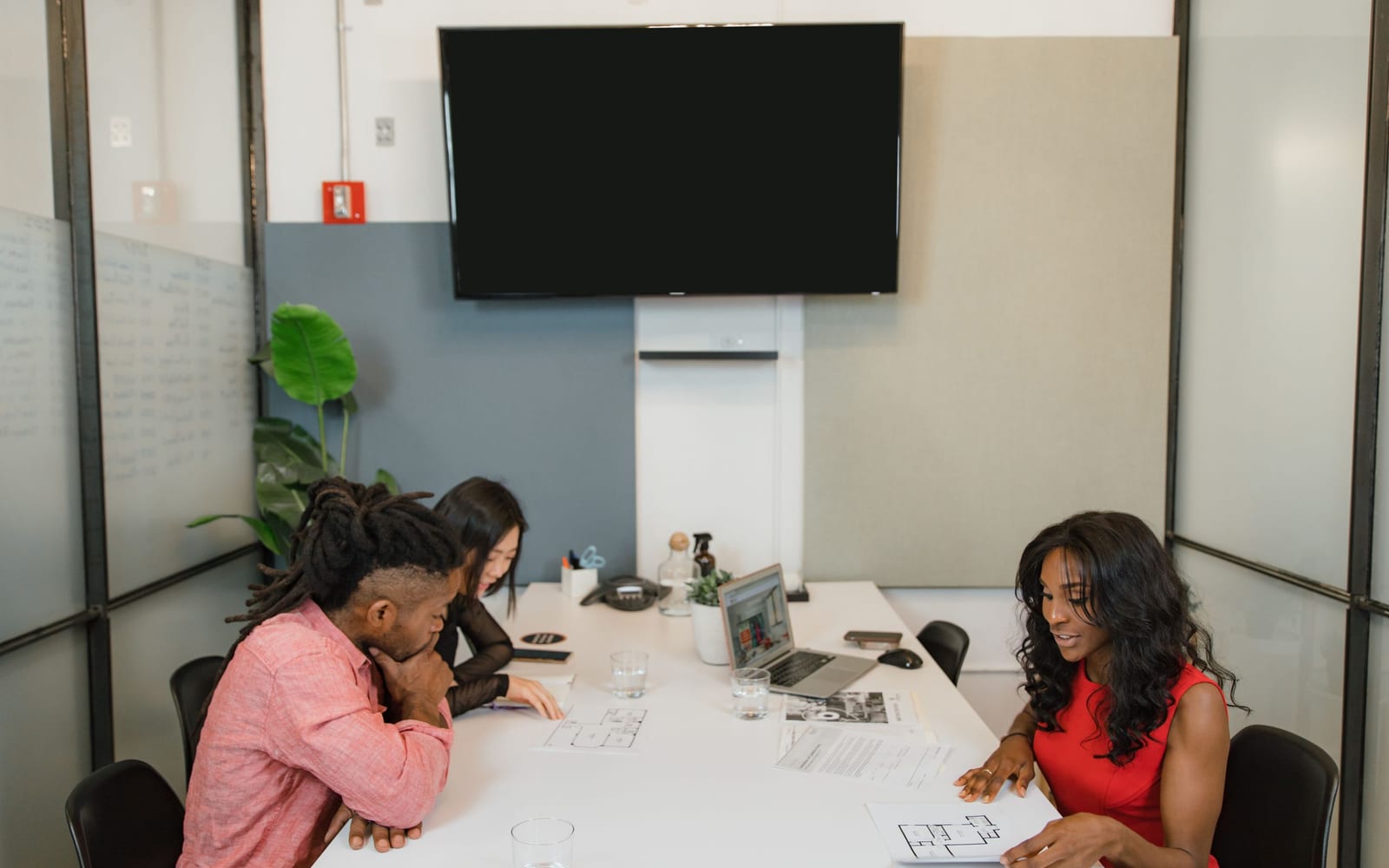 An enterprise meeting in a glass-walled conference room.